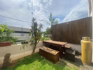 Vista externa de um quintal com gramado e cerca de madeira.