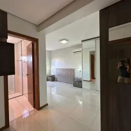 Hall de entrada com piso claro e iluminação bem distribuída.