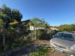 Foto externa de uma propriedade em Lajeado, Brasil, mostrando a vegetação e um carro estacionado.