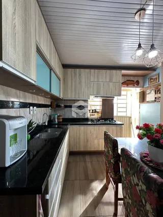 Foto de uma cozinha com armários de madeira e piso de madeira.