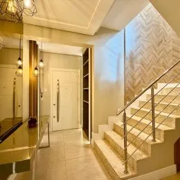 Foto de um corredor com escadaria e parede texturizada.