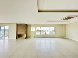 Sala ampla com lareira e grande janela de vista para o exterior.