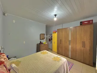 Quarto com cama e armário de madeira em um imóvel no Brasil.