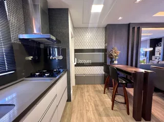 Cozinha moderna com armários escuros e bancadas de aço inoxidável.