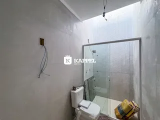 Foto de um banheiro com box de vidro e vaso sanitário branco.