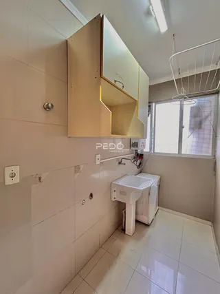 Foto de um banheiro com revestimento cerâmico e bancada branca.