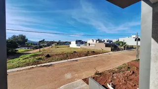 Vista da propriedade com estrada de terra e vegetação ao fundo.