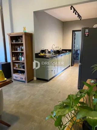 Sala de estar com estantes de madeira e acesso a outra área interna.