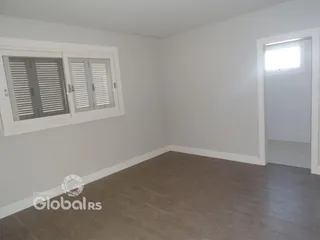 Ambiente interno de uma sala com janela e parede branca em um imóvel.