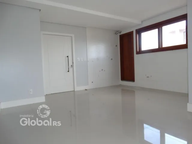 Interior de uma sala com paredes brancas e piso claro.