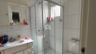 Foto de um banheiro com box de vidro e pia.