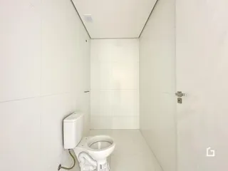 Interior de um banheiro com piso e paredes brancas.