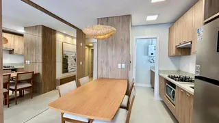 Interior de uma sala de estar com painéis de madeira e mesa de jantar.