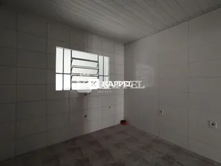 Foto interna de um ambiente com paredes brancas e piso de cerâmica.