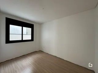 Foto de um cômodo interno com piso de madeira e janela.