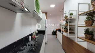 Cozinha moderna com bancadas pretas e armários brancos.