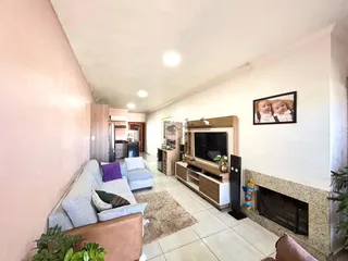 Sala de estar com sofá e lareira em um apartamento.
