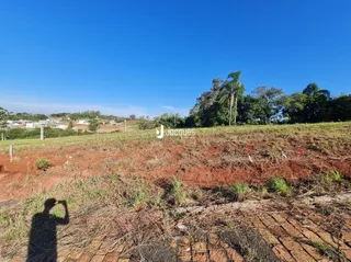 Campo aberto de terra seca com vegetação rasteira.