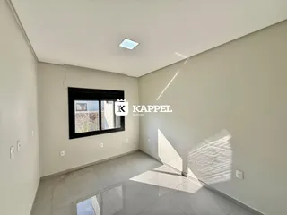 Uma sala de estar ampla com paredes claras e piso de cerâmica é visível na propriedade.