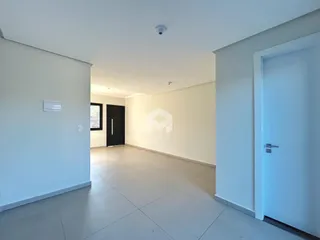 Hall de entrada de um apartamento moderno com paredes brancas e piso claro.