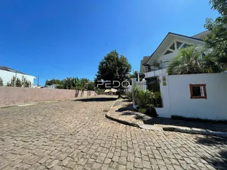 Vista da fachada de uma residência em Lajeado, Brasil, com uma área pavimentada à frente.