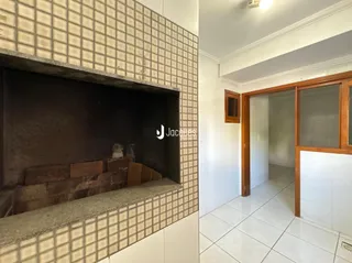 Foto de uma área interna com lareira e passagem para um corredor.