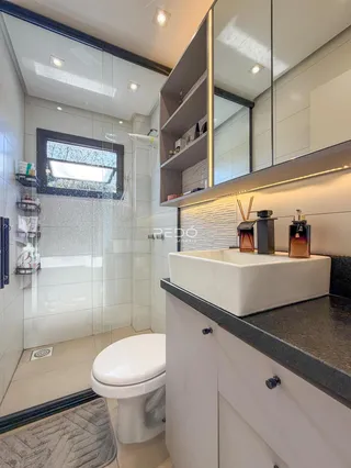 Foto de um banheiro moderno com box de vidro e revestimento cerâmico.