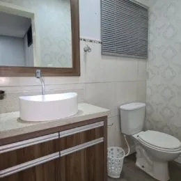 Foto de um banheiro com bancada e vaso sanitário.