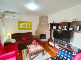 Sala de estar com sofá marrom e lareira em Lajeado.