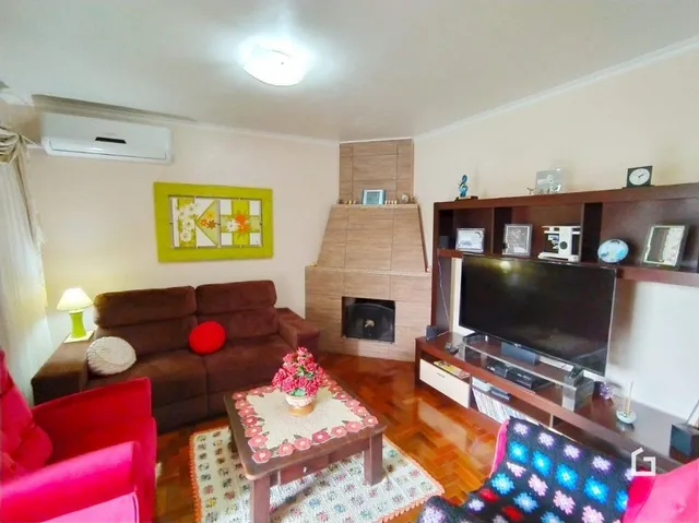 Sala de estar com sofá marrom e lareira em Lajeado.