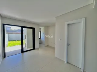 Sala de estar com porta de vidro abrindo para o quintal.