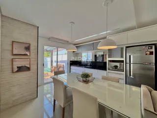 Ambiente moderno de sala de jantar e cozinha com ilha central.