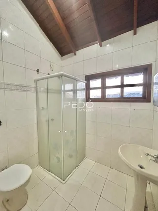 Foto de um banheiro com revestimento de cerâmica branca e box de vidro.