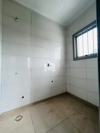 Interior de um corredor com paredes brancas e piso de concreto.