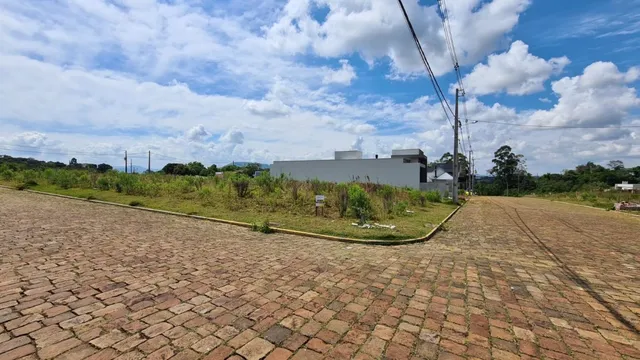 Vista externa de uma área pavimentada com grama no exterior.