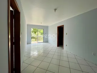 Corredor interno de um imóvel com piso de cerâmica e portas de madeira.