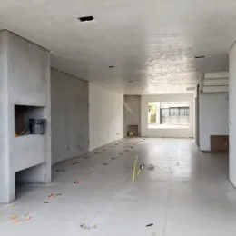 Ambiente interno vazio com piso claro e paredes brancas.