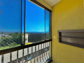 Vista da paisagem verde e céu azul através de uma janela com grade de segurança.
