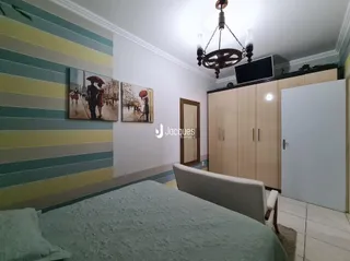 Quarto com cama e armários de madeira em um imóvel.