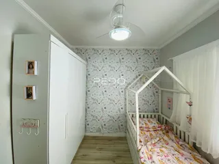 Quarto com armários brancos e cama de madeira em um ambiente claro.