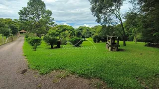 Vista externa de um gramado verde com árvores e um caminho de terra.