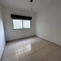 Ambiente interno com piso de cerâmica e janela.
