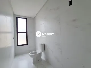 Foto de um banheiro com revestimento em mármore branco e janela.