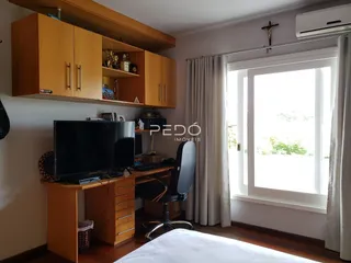 Quarto com armários de madeira e uma janela grande no interior da casa.