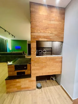 Vista interna de uma sala com parede de tijolos aparentes.