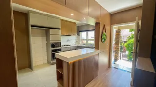 Vista da cozinha moderna com armários de madeira e ilha.