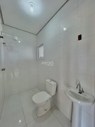 Foto de um banheiro com revestimento cerâmico branco.