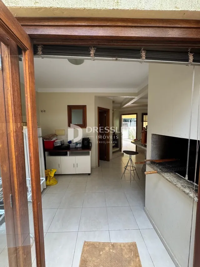Vista de um corredor interno com piso de cerâmica e molduras de madeira.