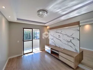 Sala de estar com piso de madeira e porta de vidro que dá acesso ao exterior.