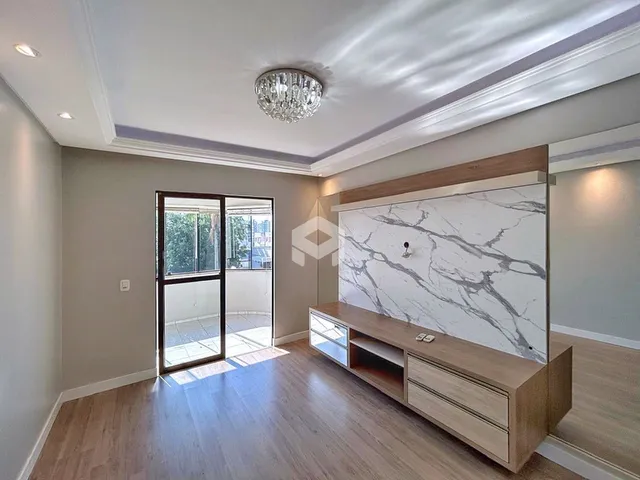 Sala de estar com piso de madeira e porta de vidro que dá acesso ao exterior.
